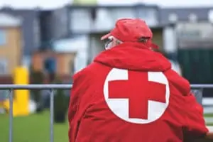 Man with red jacket with red cross on the back