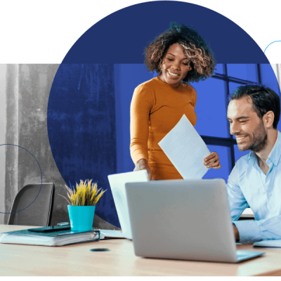 two people in an office working together on computers